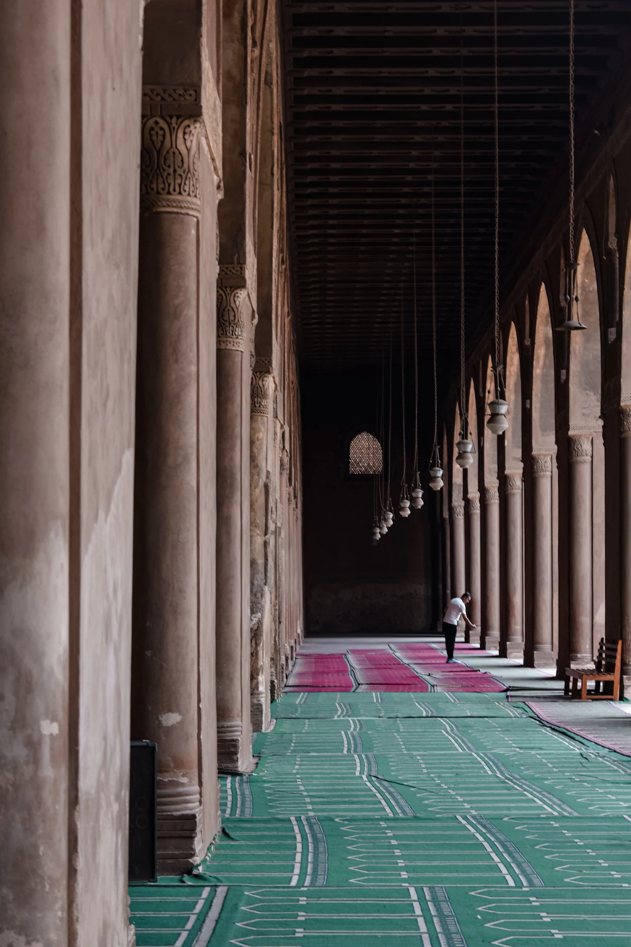 Säulenhalle einer Moschee mit Gebetsteppichen