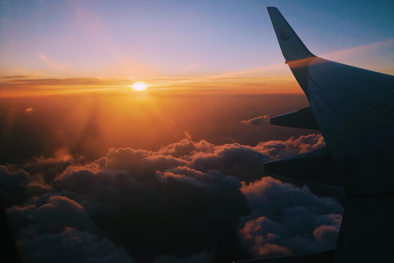Sonnenaufgang über einer Wolkendecke, aus dem Flugzeug gesehen
